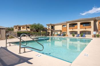 A swimming pool in front of a building with a metal ladder.